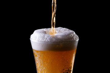vaso de cerveza fría sobre fondo oscuro. Cerveza cayendo. Aislado.  Espacio para texto