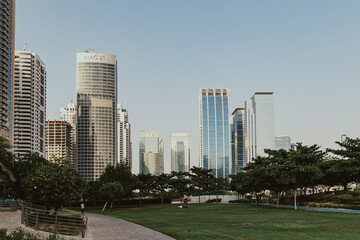 Fototapeta na wymiar Public park area landscape with futuristic modern skyscrapers view 