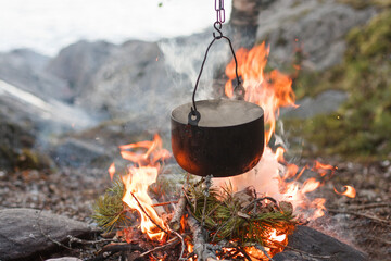 Camp kitchen, pot on the fire. On the road again. Hiking in the forest