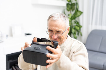 Portrait of senior man sitting on the sofa while playing video game with virtual reality glasses