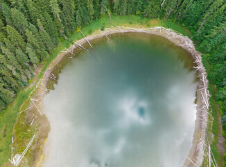 aerial drone landscape of a lake and forest with reflection of the sky and clouds