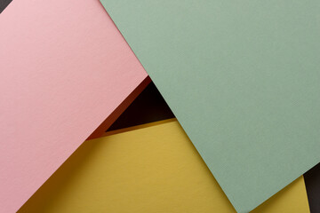 pale pink, green, and yellow paper background with blank space