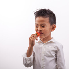 boy eating strawberries sour face