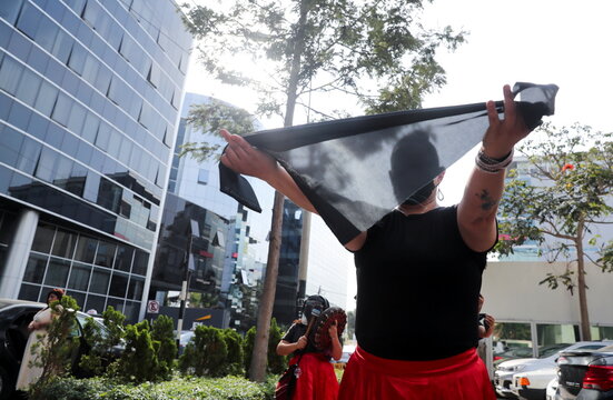 Performers stage a protest outside the offices of Spanish energy firm Repsol, in Lima