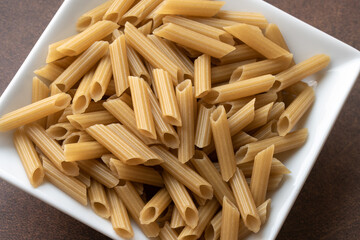 Uncooked Penne Pasta in a Bowl