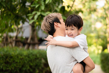 Fototapeta premium Happy Asian little boy enjoy playing and walking at the park with daddy.