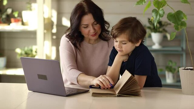 Mom and son are engaged in online school doing tasks