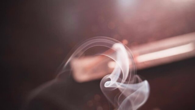 Dense white smoke from an incense stick completely covers the frame, defocus