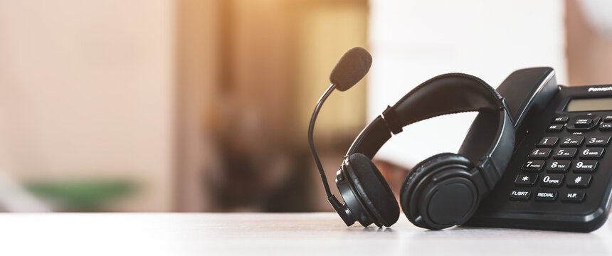 Customer service concept. Close-up headset and telephone for communication helpdesk IT support or call center and online customer services.