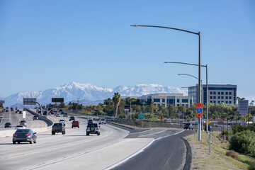 Morning snow-capped mountain and freeway view of the downtown skyline of Corona, California, USA.