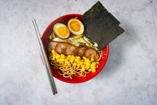a bowl of shoyu sauce ramen with corn filling, chasu chicken, boiled eggs and leeks Bowl of mouth watering japanese ramen for single serving. Asian noodle soup. close up, selective focus.