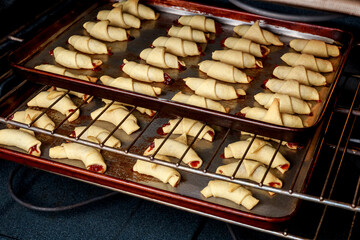 Baking rolled up crescent cookies stuffed with jam.