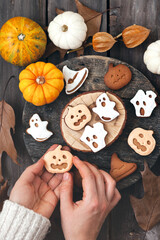 Homemade halloween holiday treats for kids. Gingerbread cookies on wooden board, decorated with pumpkins and autumn leaves. Top view