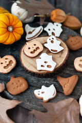 Homemade halloween holiday treats for kids. Gingerbread cookies on wooden board, decorated with pumpkins and autumn leaves. Top view