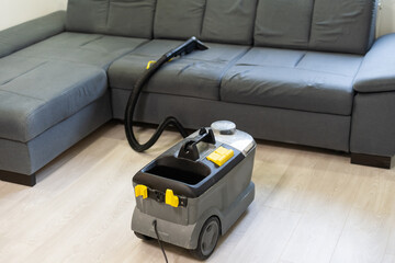 Hand cleaning a sofa with a steam cleaner, Home cleaning concept