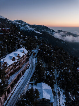 Landscape view of vehicle moving on road covered with snow during sunset Dalhousie, Himachal Pradesh, India.