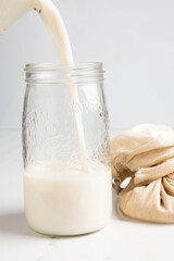 Nut milk being poured into a jar