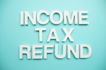 Income Tax Refund alphabet letters on blue background