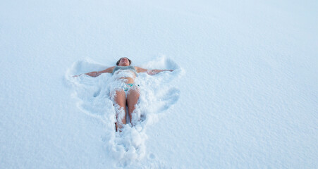 woman swims in a swimsuit in a snowy snowdrift. Tempering concept, winter swimming, happy healthy...