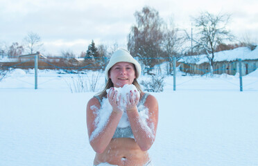 woman meditates in a swimsuit in snow drifts. Tempering concept, winter swimming, happy healthy...