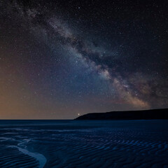 Digital composite image of Milky Way and Epic Absolutely beautiful landscape images of Holywell Bay beach in Cornwall UK