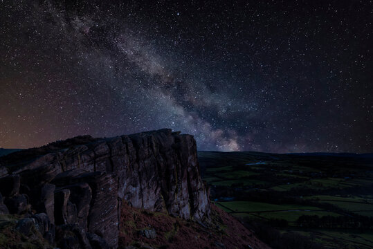 Digital composite image of Milky Way and Epic pic Peak District Winter landscape of view from top of Hen Cloud over countryside and towards Tittesworth Reservoir