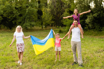 Fototapeta premium Ukraine's Independence Flag Day. Constitution day. family with the flag of ukraine in field. 24 August. Patriotic holiday.