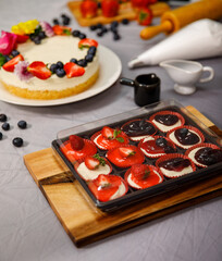 Sweet cheesecake mini decorated with fresh berry fruits, and flowers on a wooden plate , for birthday, Valentine day and celebration