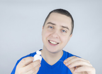 Dental floss close up. A man in front of a mirror brushes his teeth with flossing. The concept of...