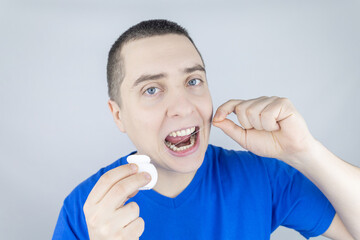 Dental floss close up. A man in front of a mirror brushes his teeth with flossing. The concept of...