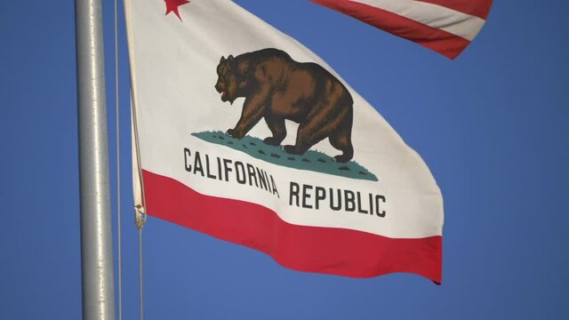 United States flag and california state flag waving in the wind in slow motion 180fps