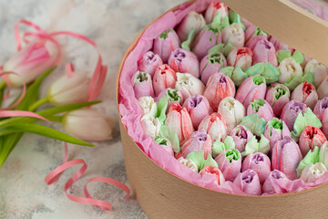 Handmade marshmallows in wooden packages on a light background with flowers. The concept of the holidays Women's Day and Valentine's Day.