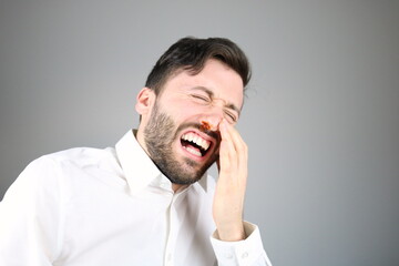 Caucasian man bleeding from his nose, painful expression 
