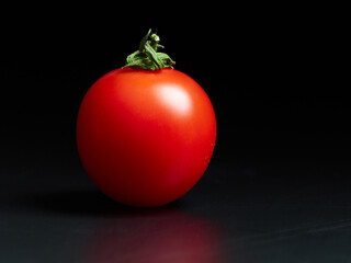 Cherry tomato close-up on a completely black background