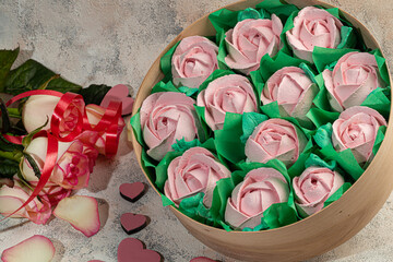 Handmade marshmallows in wooden packages on a light background with flowers. The concept of the...