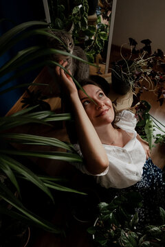 Beautiful Woman And Her Cat With A Lot Of House Plants At Home