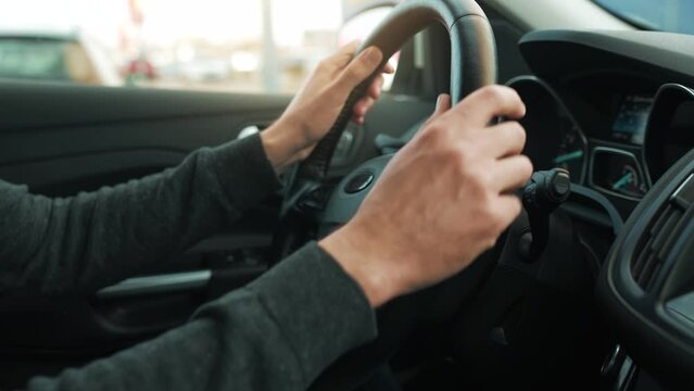 Man driving car through a parking and is looking for a place to park and drives into it
