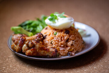 Close-up fried chicken in American fried rice dish, Thai traditional food fried rice mixed tomato sauce and grain with fried chicken, fresh vegetables, egg in side dishes.