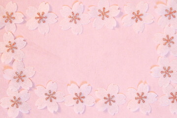 Cherry blossom petals paper crafts on pink textured paper background for wall paper.  Blank for copy space.