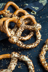 Fresh prepared homemade soft pretzels. Different types of baked bagels with seeds on a black background.