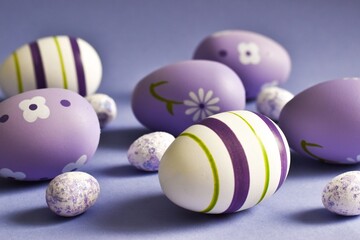 Colorful Easter eggs on very peri purple background. Selective focus. Happy easter holiday. Greeting card for easter