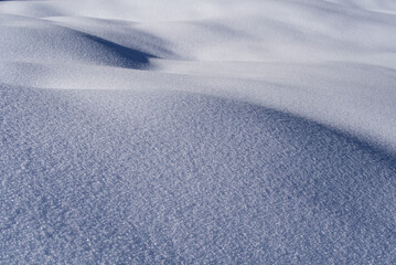 Beautiful curvy surface of snow layer in the Swiss Alps on a sunny winter day. Photo taken January 15th, 2022, Murren, Switzerland.