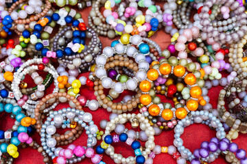 Fototapeta na wymiar A close-up background of numerous bracelets made of colorful beads.