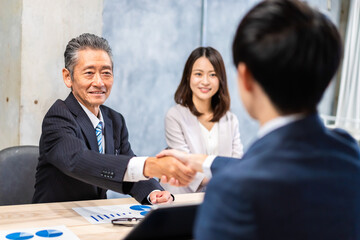笑顔で握手をするビジネスパーソン
