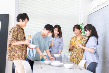 みんなで食事をする若い男女
