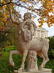 Sculpture of a centaur in an ancient park on a bright autumn day. - obrazy, fototapety, plakaty