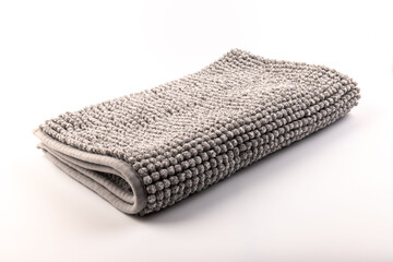 Soft grey bath mat against white background, closeup.Bath Accessories. Top view.