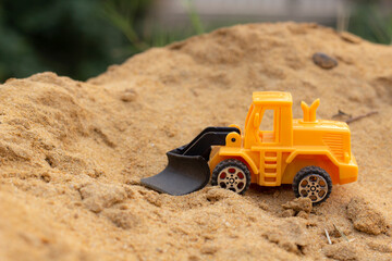 truck toy on plie of sand , under construction concept