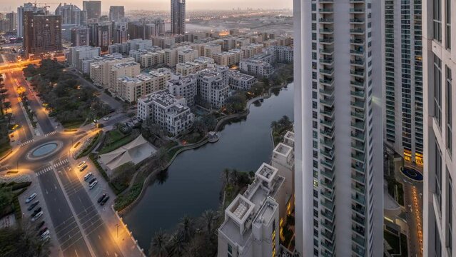 Pond and low rise buildings in Greens district aerial night to day timelapse.