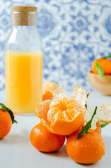 Bottle of tangerine juice and fresh fruit on marble